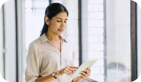 Mulher em pé mexendo no tablet representando PEP e PEM - Pessoas Politicamente Expostas e Pessoas Expostas na Mídia