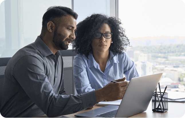 Um homem e uma mulher utilizando um computador