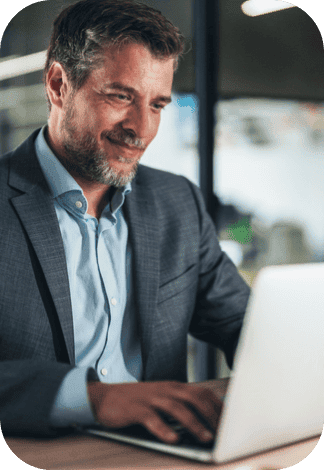 homem sorrindo enquanto digita em um notebook