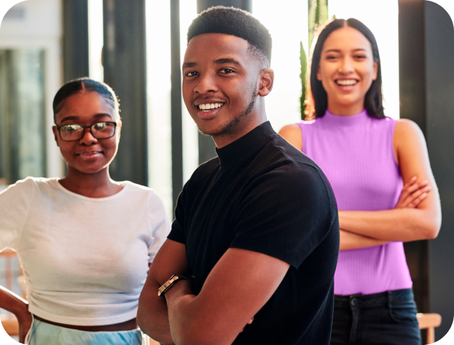 Três jovens sorrindo em um ambiente moderno, destacando diversidade e amizade, com foco em pessoas felizes e confiantes.