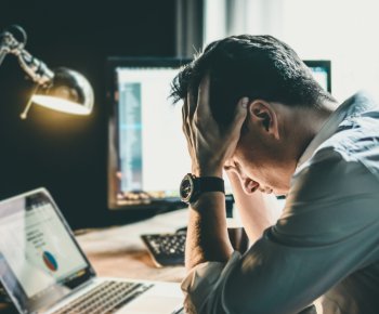 Empreendedor estressado com as mão na cabeça, demonstrando muito cansaço