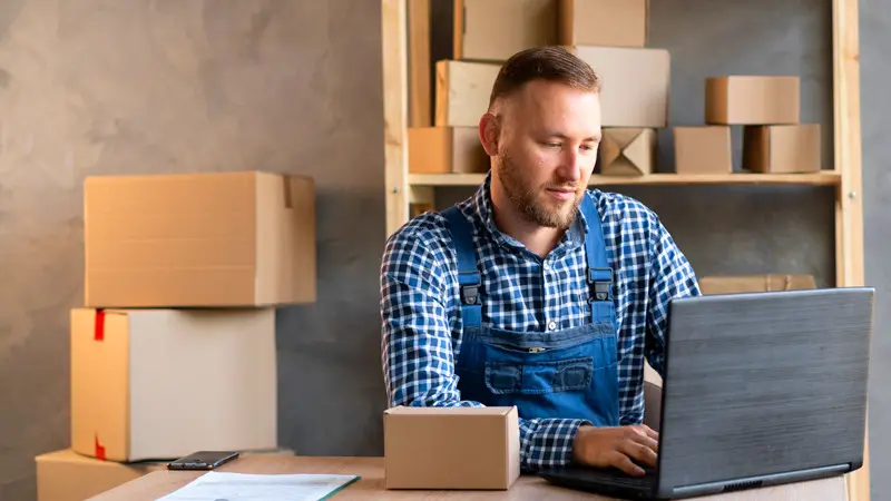 homem adulto empreendendo com um estoque de caixas em volta