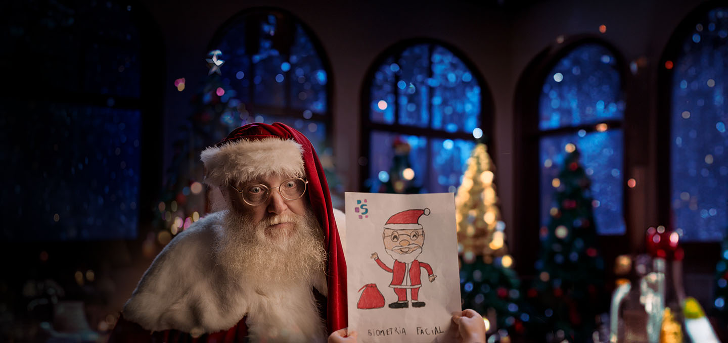 Imagem de um papai noel segurando o desenho de um papai noel feito por uma criança