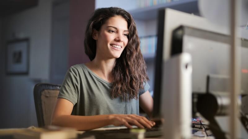 Mulher preenchendo o perfil do linkedin com computador